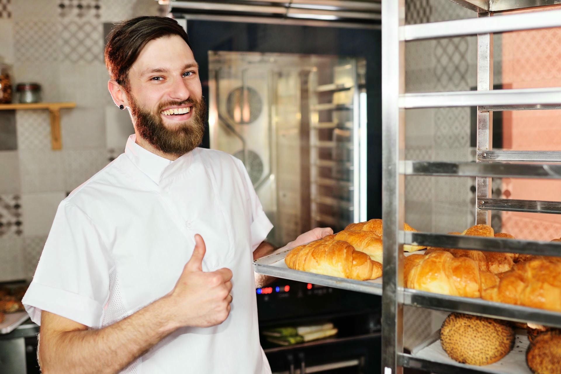 4626998 baker white uniform holding his hands tray full freshly baked croissants scaled